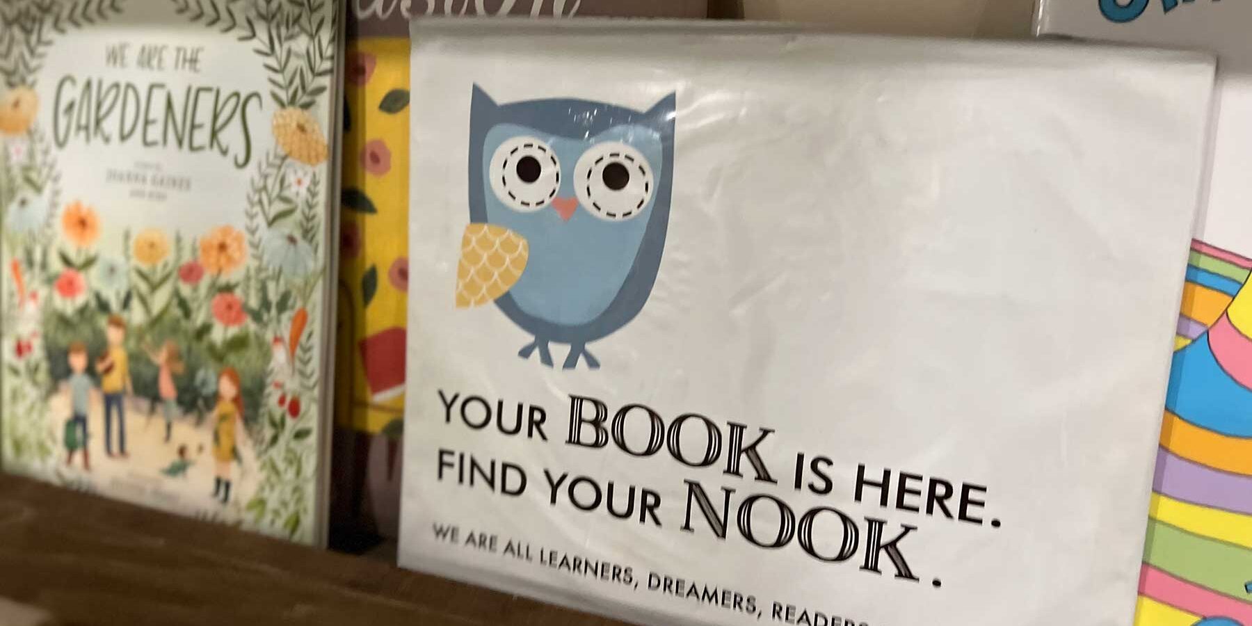 Books on a shelf with a sign "Your Book is here, find your Nook"